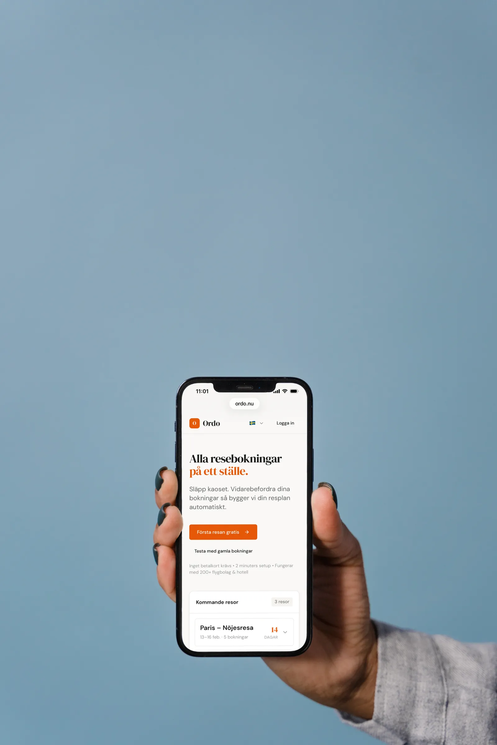 Hand håller iPhone med Ordo reseapp mot blå himmel – automatisk tidszon