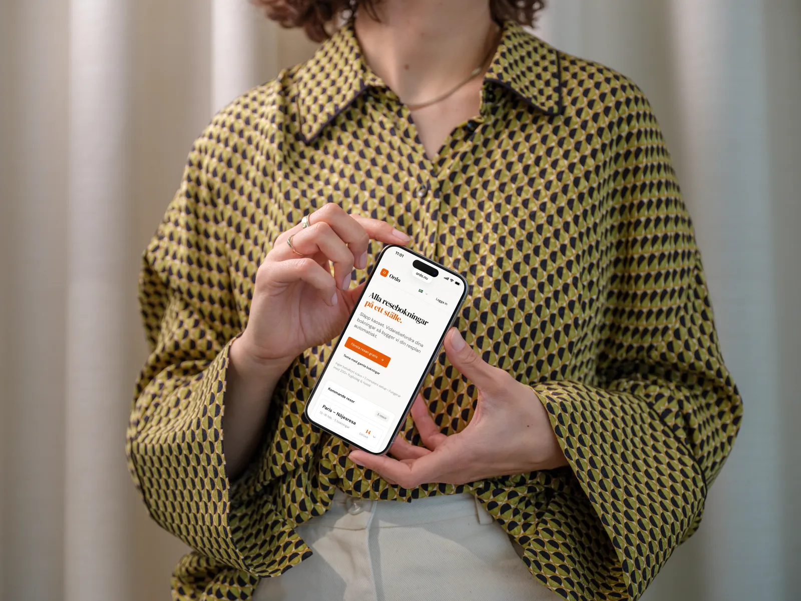 Kvinna visar Ordo reseapp på svenska på sin mobil